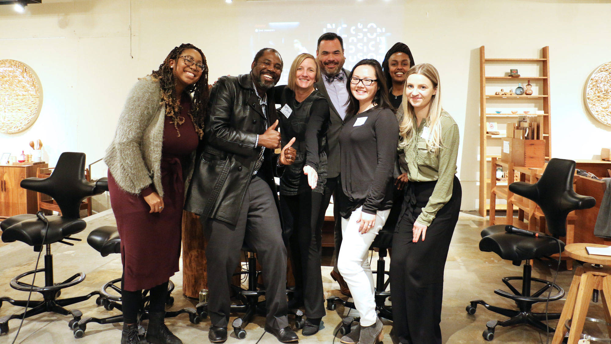 Five panel members and two moderators pose together for a picture at the Design Week Portland event.