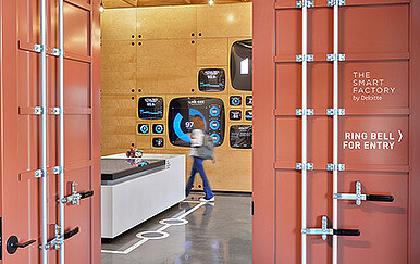 A person standing in a room with lockers and a desk.