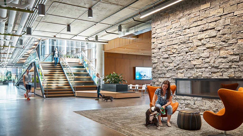 A person sitting in a chair in a large room with stairs.