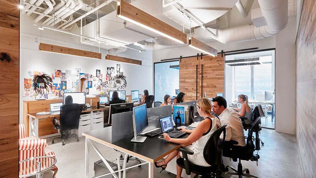 A group of people sitting at a table with computers.
