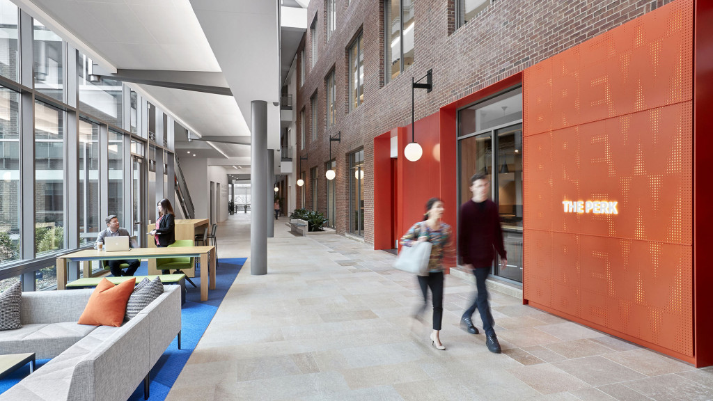 A couple of women walking down a walkway between buildings.