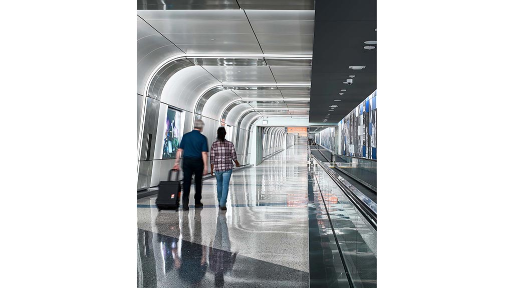 A couple of people walking down a train platform.