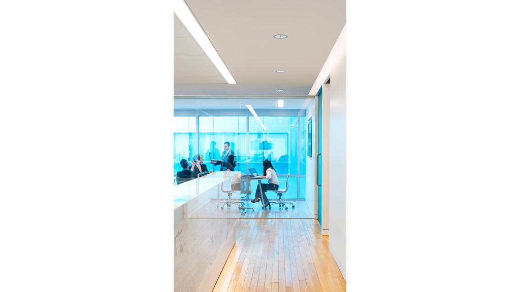 A group of people sitting at a table in a room with large windows.