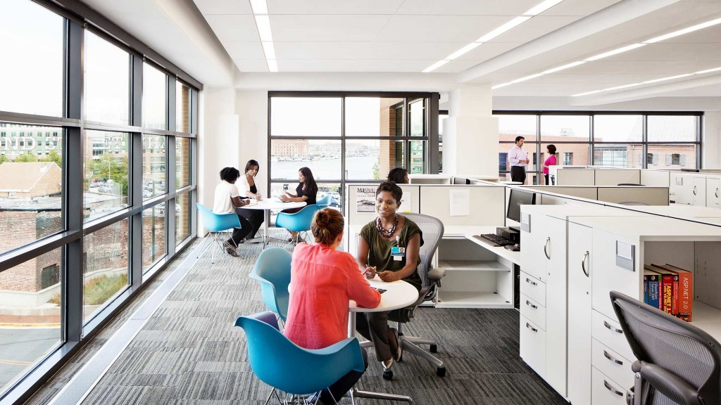 A group of people sitting at a table in a large room.