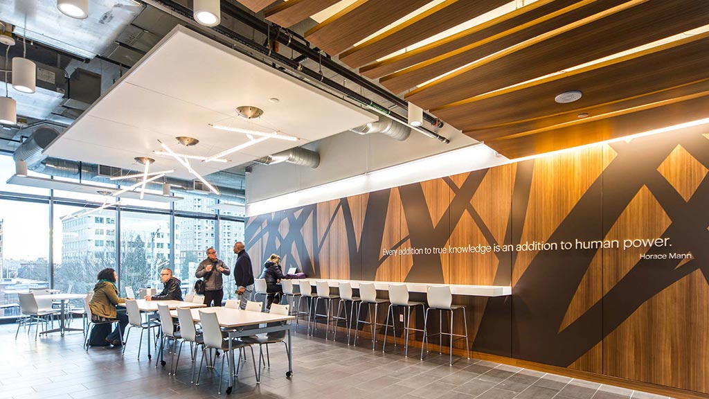 A group of people in a room with tables and chairs.