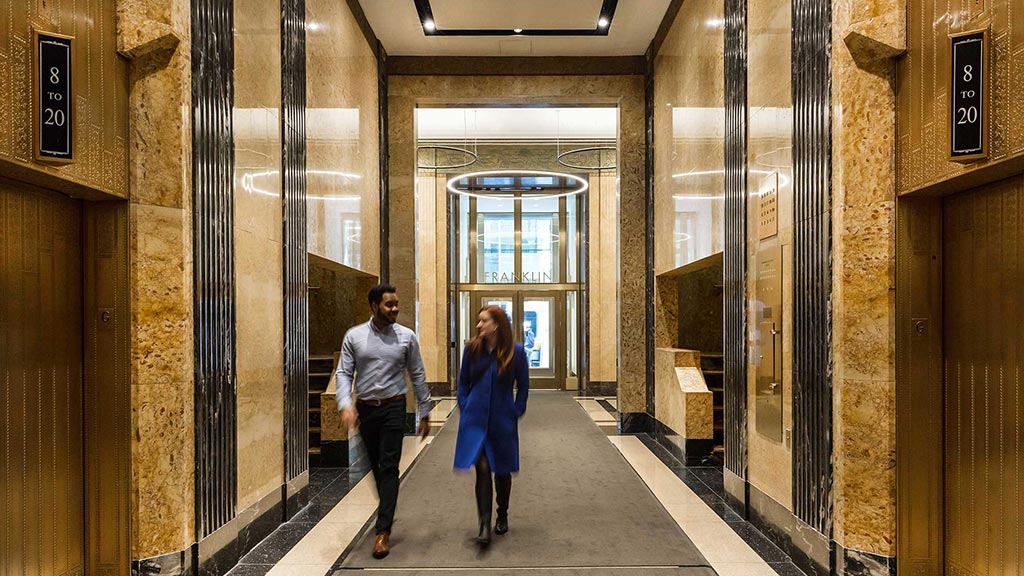 A man and a woman walking through a hallway.