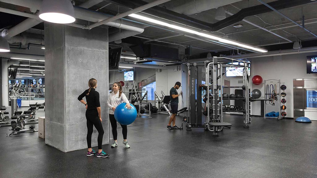A group of people in a room with machines and a blue ball.