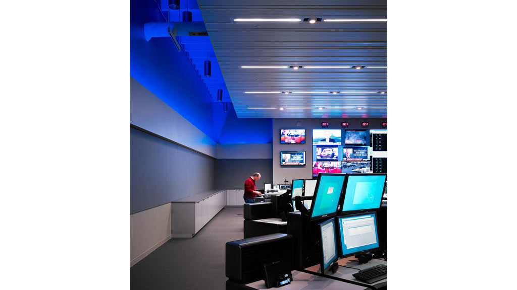 A person standing in front of a row of computers.