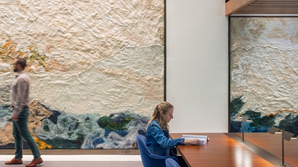 A man and a woman looking at a large piece of art.