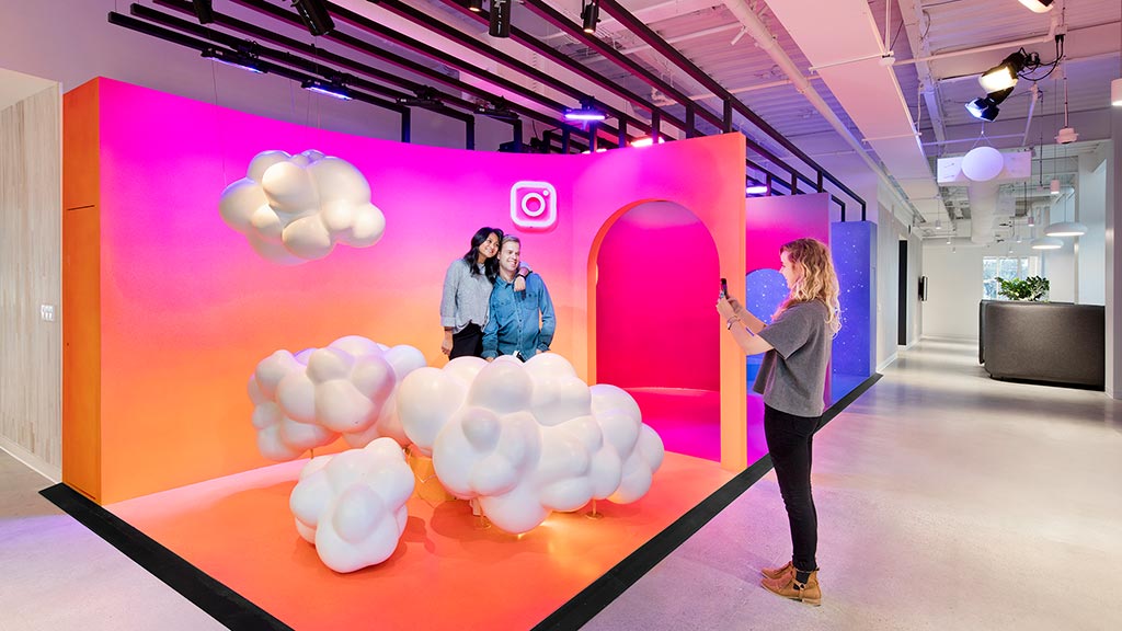 A person standing next to a wall with balloons.