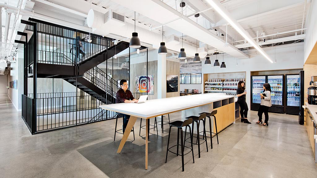 People standing in a room with tables and chairs.