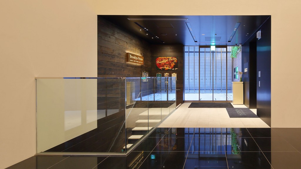 A room with a glass door and a glass floor with a sign on it.