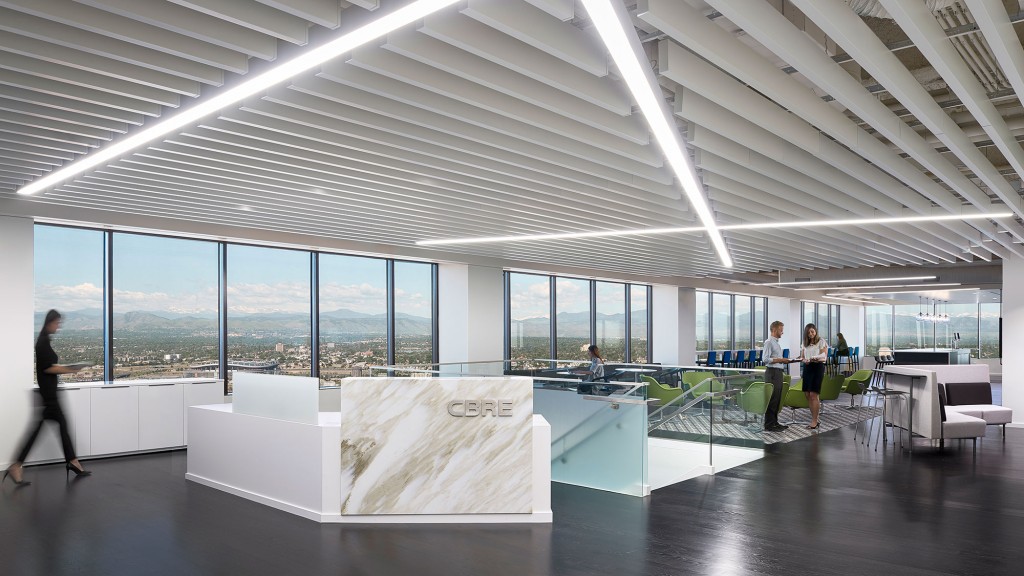 A group of people in a room with large windows and a large white table with a sign on.