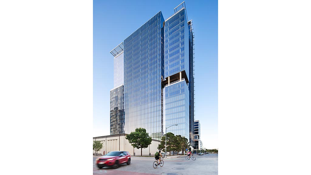 A tall building with a street and cars.