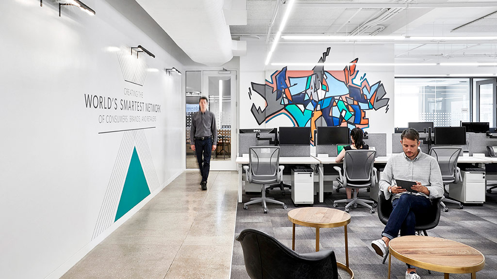 A person sitting in a chair in a room with a large screen.