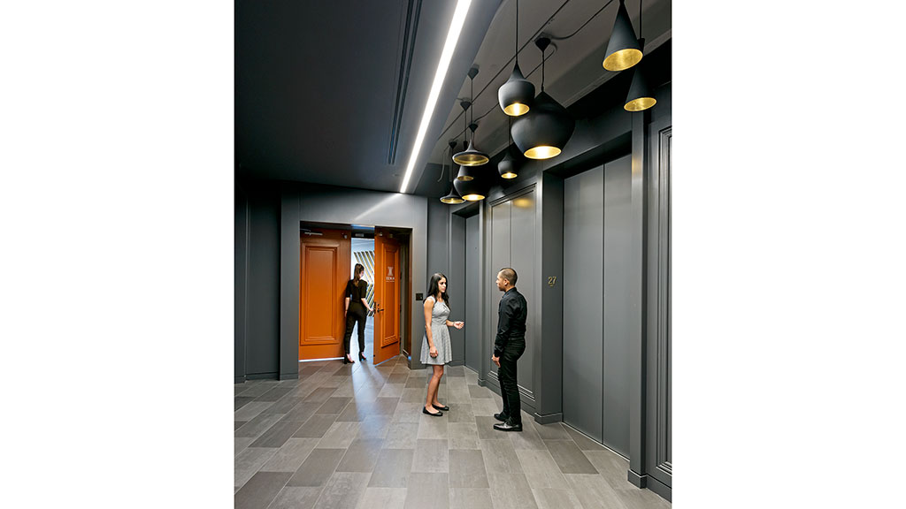 A group of people standing in a hallway with lights.