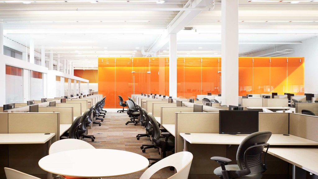 An empty office with tables and chairs.