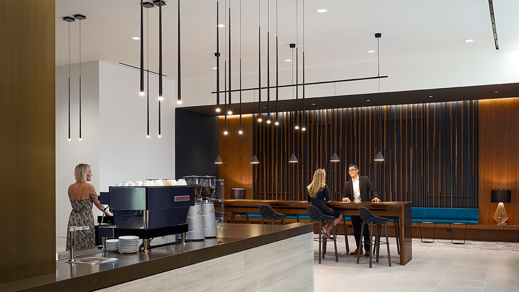 A man and woman sitting at a table in a room with a large window.