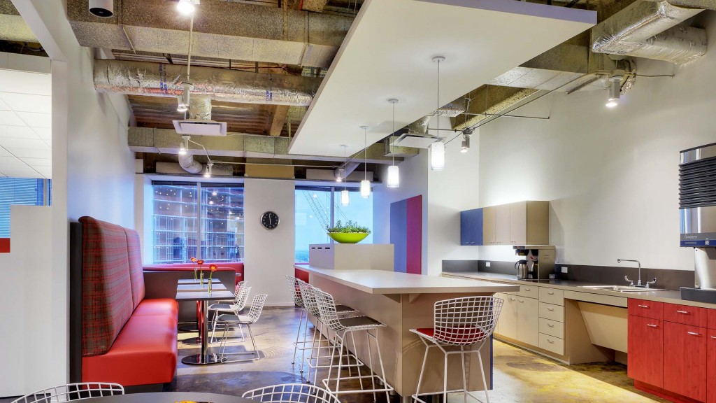 A large kitchen with a red couch.