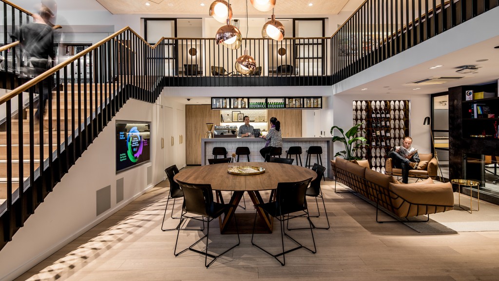 A group of people sitting at a table in a large room.