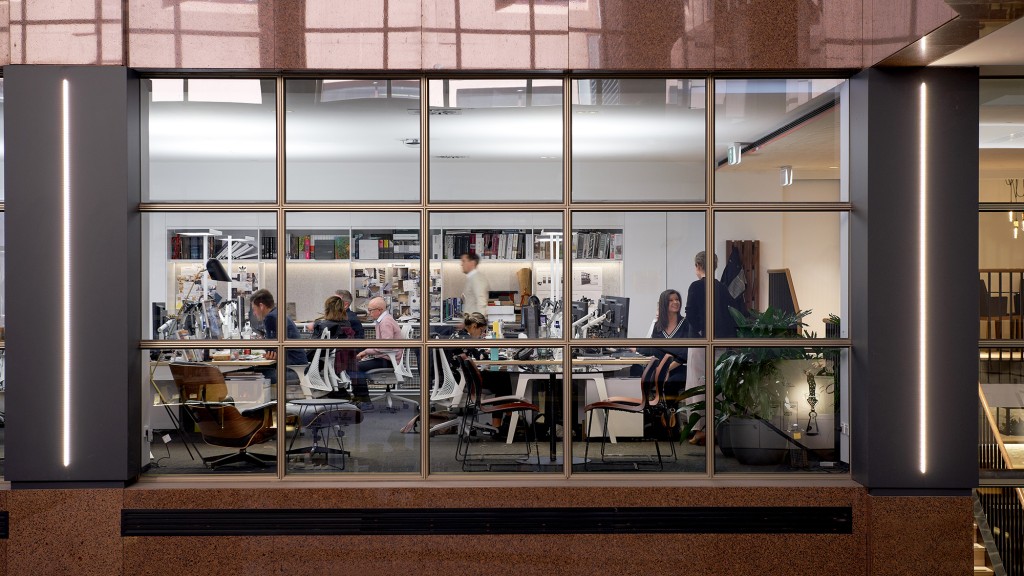 A group of people sitting at a table in a room with windows.