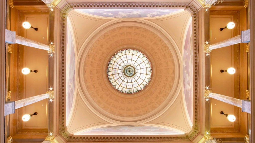 A large ornate ceiling with a clock.