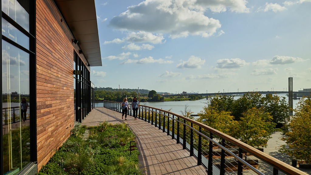 A group of people walking on a bridge over a body of water.