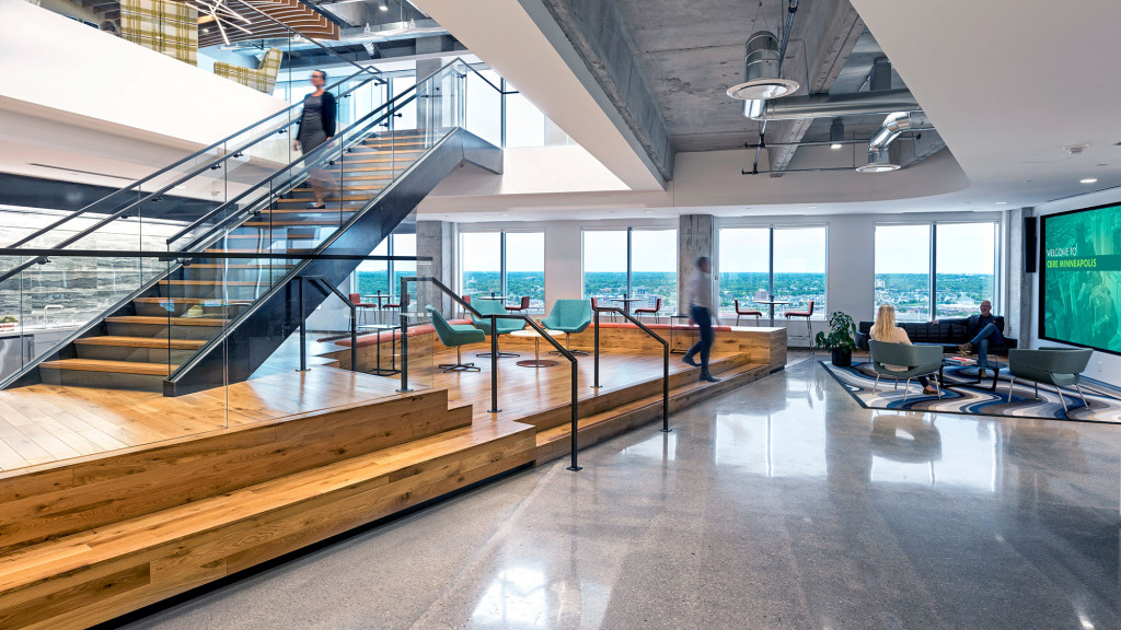 A large room with a staircase and people walking around.