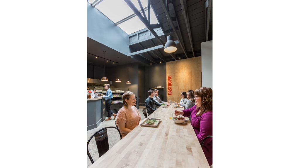 A group of people sitting at a table eating food.