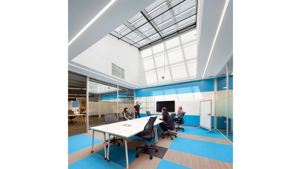 A group of people sitting at a table in a room with blue walls.