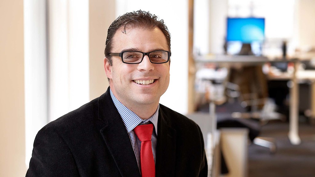 A man wearing glasses and a suit.