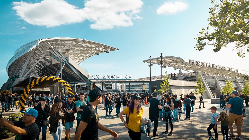 A crowd of people walking around a stadium.