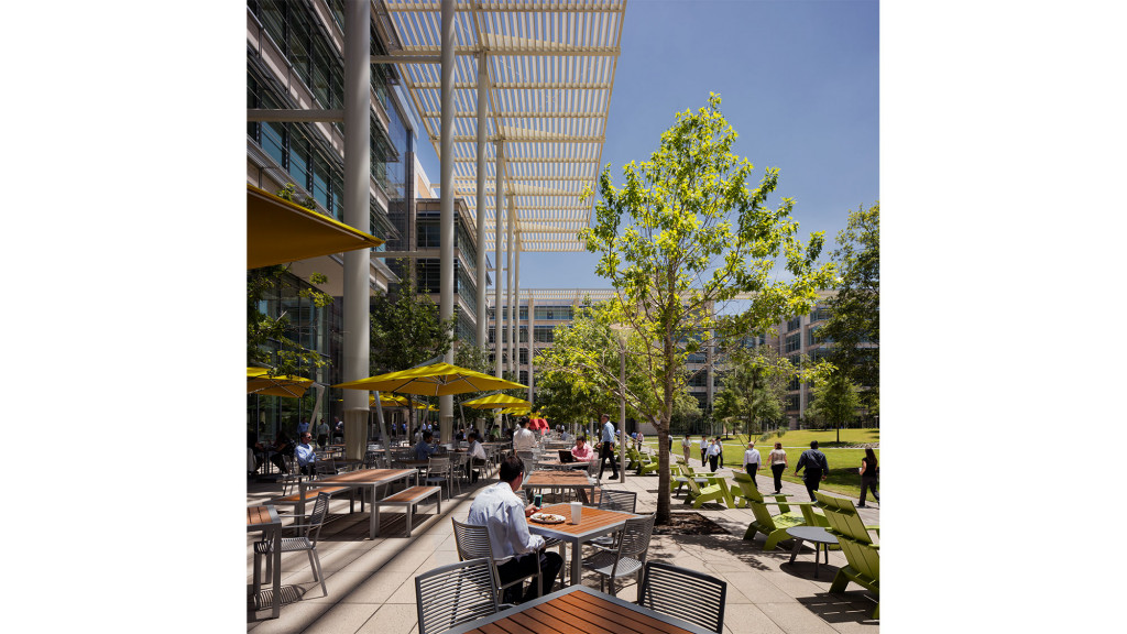 A group of people sitting at tables outside.