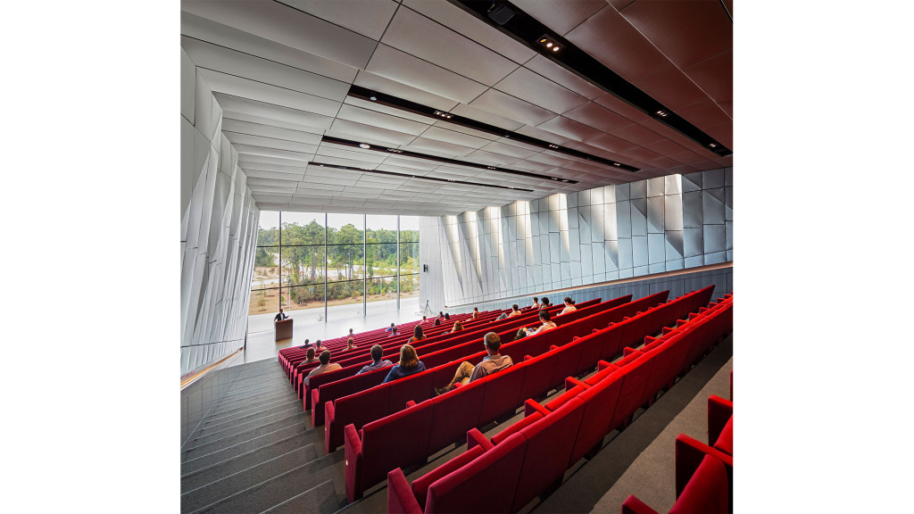 A group of people sitting in a red auditorium.