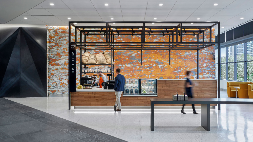 A man and woman walking in a large room with a large glass wall.