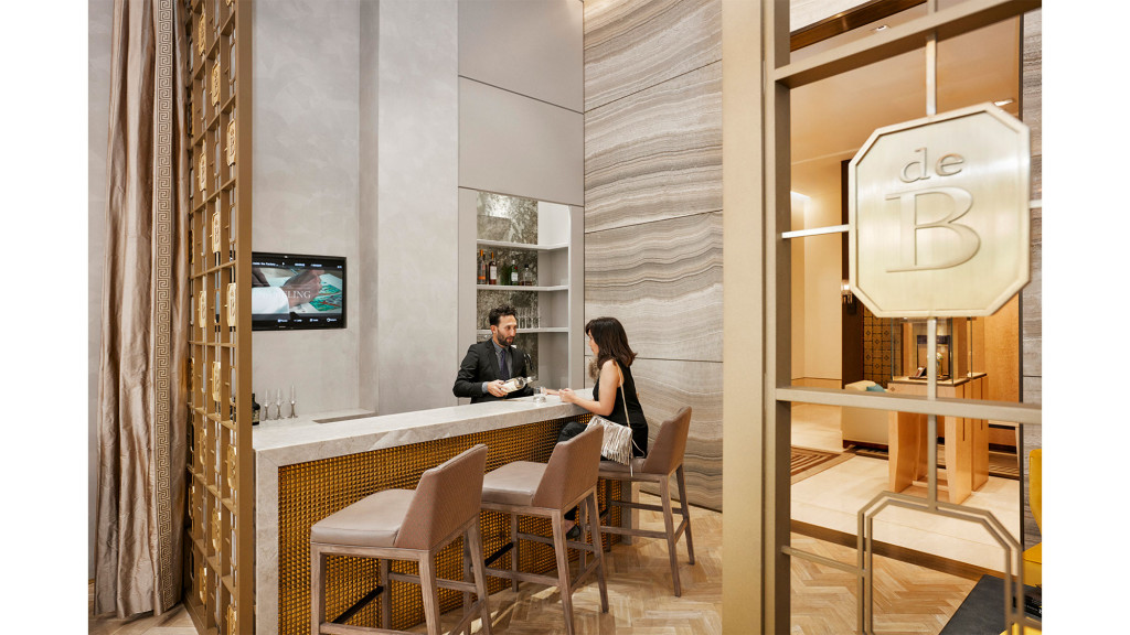 A man and woman sitting at a table in a room with a tv.
