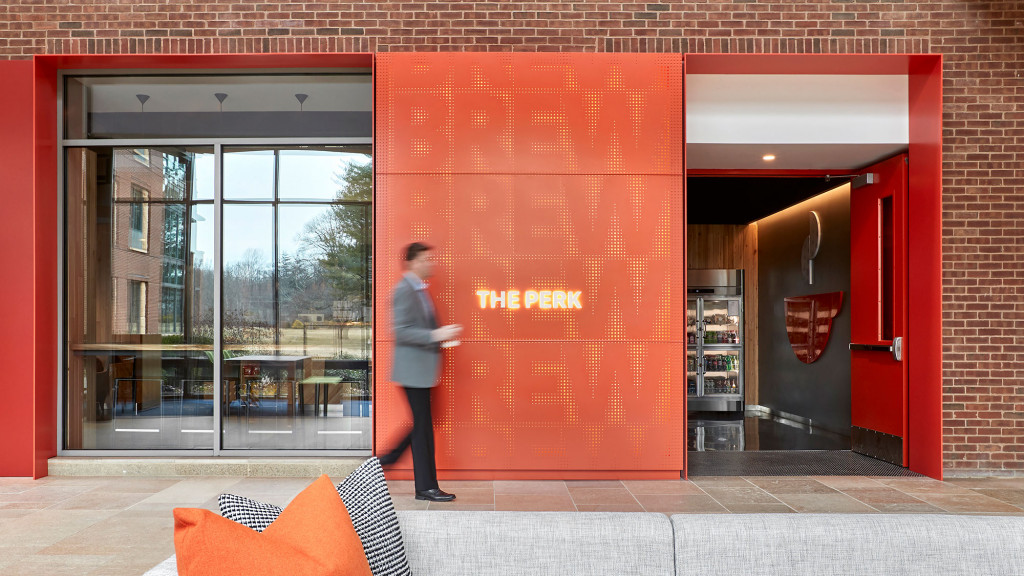 A person standing in front of a building with a large red door.