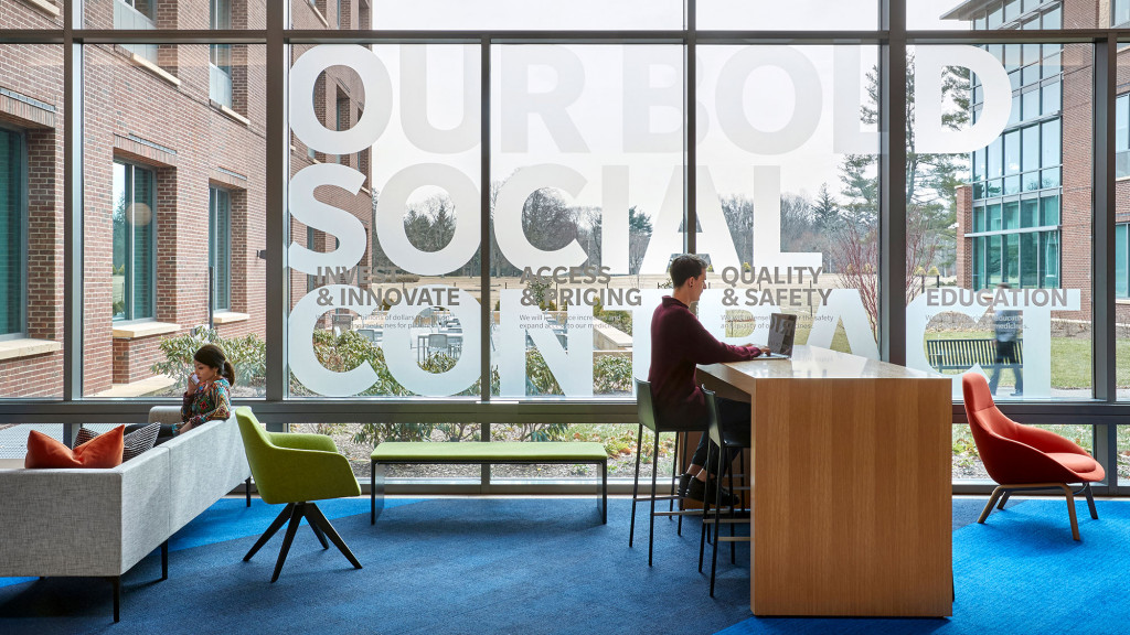 A man and woman sitting at a table with a laptop.