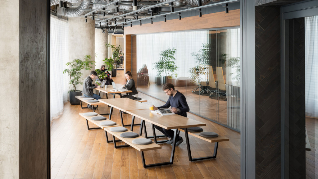 A group of people sitting at a table in a room with windows.