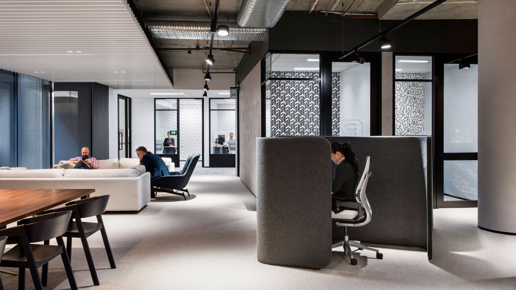 A group of people sitting in a room with a table and chairs.