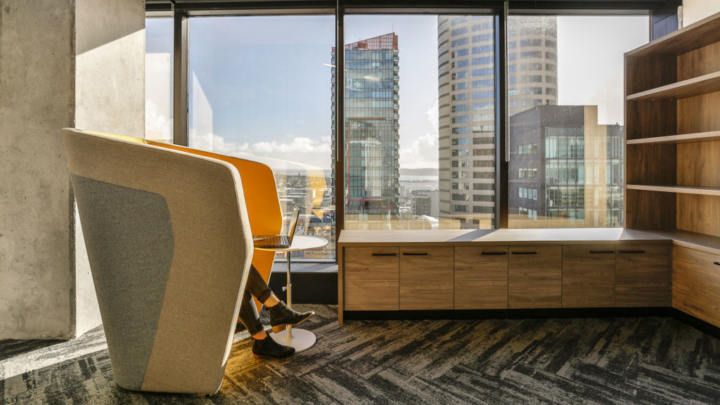 A chair in a room with a window and a view of a city.