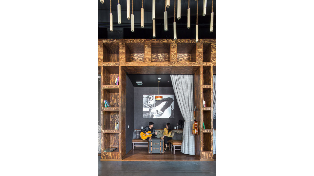 A room with a wood cabinet and a couple people sitting at a table.