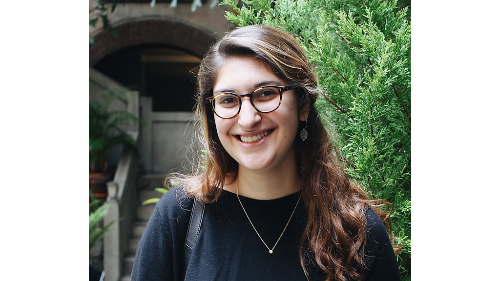 A woman with glasses smiling.