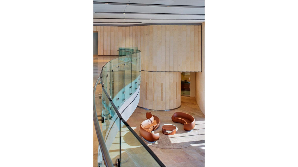 A room with a glass wall and a table with chairs and a person sitting on it.