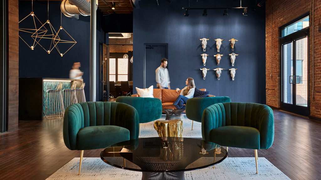 A man and woman sitting on a couch in a room with blue walls.
