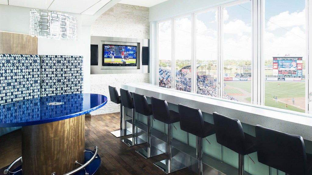 A room with a pool table and chairs and a tv on the wall.
