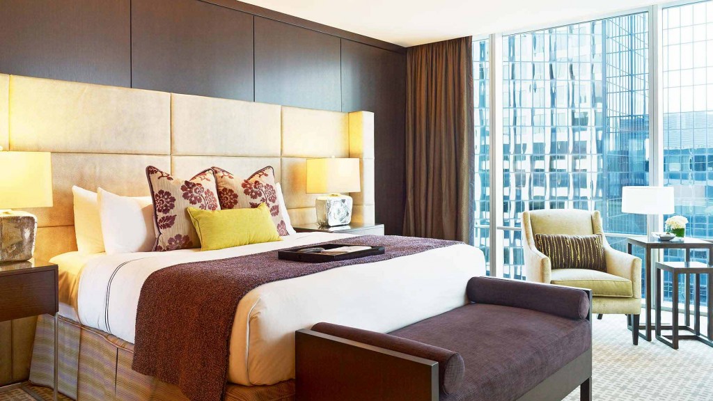 A bedroom with a bed and chairs.