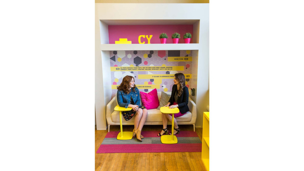A couple of women sitting on a couch.