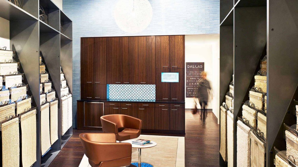 A room with a table chairs and a person walking in the distance.