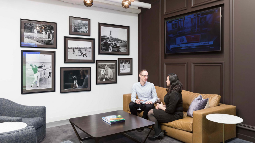 A man and a woman sitting on a couch in a living room.